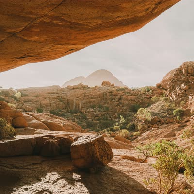 A desert valley framed by a rock overhang