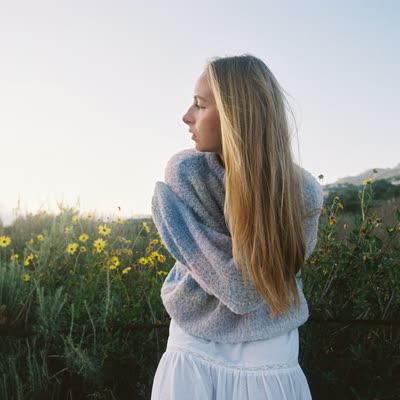 Woman in a wildflower meadow at golden hour
